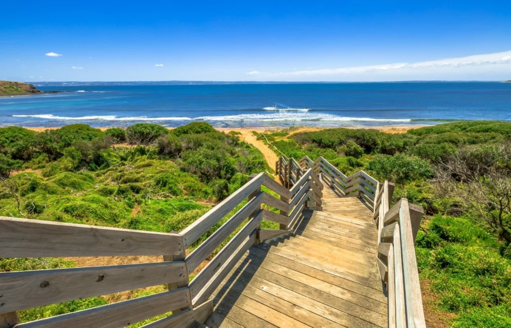 Wooden boardwalk leading to beach at Phillip Island with ocean views in Victoria Australia.