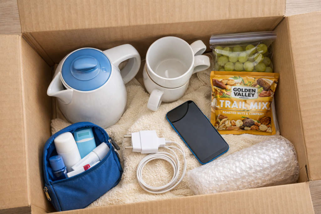 Moving essentials box with charger, toiletries, kettle and snacks by Six Brothers Removalists